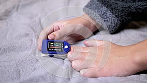 Teen Measures Pulse and Oxygen Saturation Using a Pulse Oximeter in Bedroom