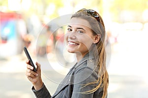 Teen with mobile phone looking at camera