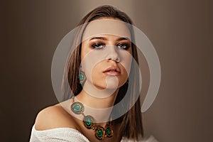 Teen model with elegant jewelery on brown background