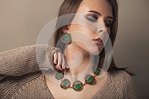 Teen model with elegant jewelery on brown background