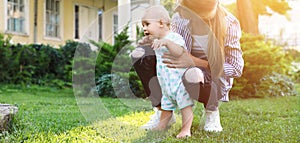 Teen nanny with cute baby on grass outdoors, space for text. Banner design