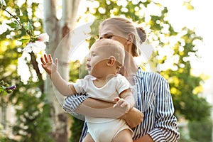 Teen nanny with cute baby on sunny day