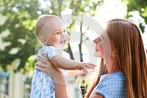 Teen nanny with cute  outdoors on sunny day