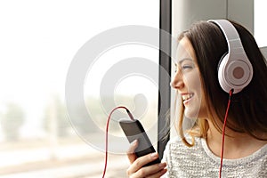 Teen passenger listening to the music traveling in a train photo