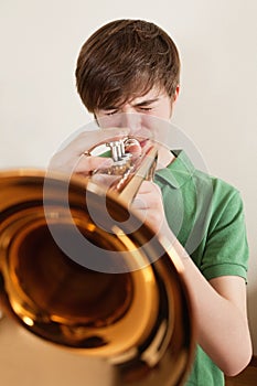 Teen playing gold trumpet