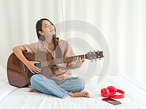Teen playing guitar relax in bedroom, enjoy leisure weekend at home