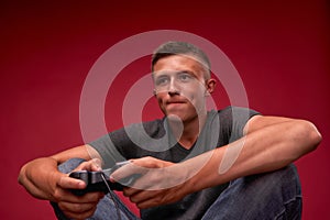 Teen playing video games. young man sitting m joystick in his hands