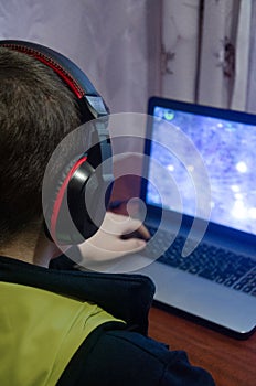 Teen plays computer games, The boy sits at home computer. Reading, boys