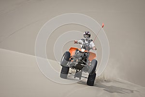 Teen quad rider wheelie in dunes photo