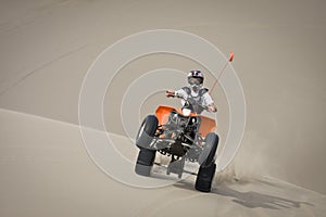 Teen quad rider wheelie in dunes photo