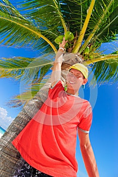 Teen reaching coconut