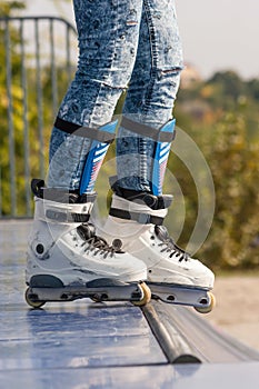 Teen with roller skates ready for a stunt on a half pipe ramp