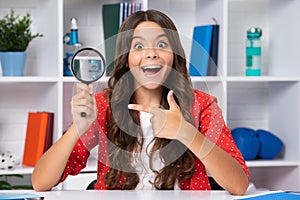 Teen school girl with magnifying glass, knowledge. Excited face, cheerful emotions of teenager girl.