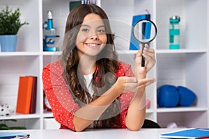 Teen school girl with magnifying glass, knowledge. Happy schoolgirl, positive and smiling emotions.