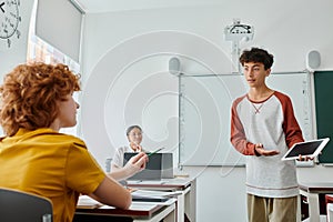 Teen schoolboy pointing at digital tablet