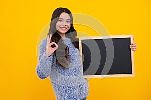 Teen schoolgirl hold blackboard. Child advertising. Back to school. Happy teenager, positive and smiling emotions of