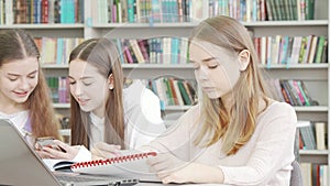 Teen schoolgirl working on an assignment at the library