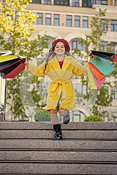 teen shopper with shopping bags outdoor. teen girl in autumn coat. autumn shopper girl explores boutiques in city