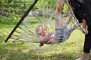 Teen sister girls and child having fun on hammock in the backyard garden