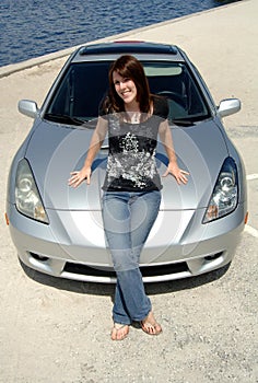 Teen sitting on car hood