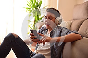 Teen sitting on floor using a smartphone at home closeup