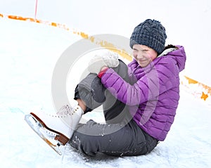 Teen skater girl fall down on ice rink