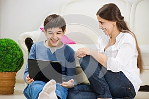 Teen son with young mother with laptop photo