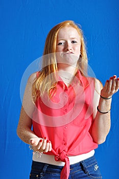 Teen speaking with her hands on blue background