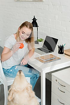 teen student girl playing with her dog while sitting