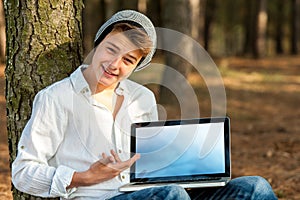 Teen student pointing at blank laptop screen.