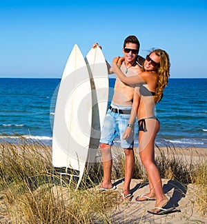 Teen surfers couple hug on the beach