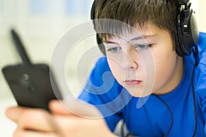 Teen using cell phone with headphones