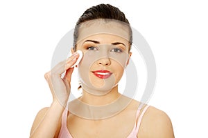 Teen using a cotton pad to remove her make-up