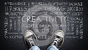 Teen Wearing Canvas Shoes on Asphalt With Creativity Word Cloud