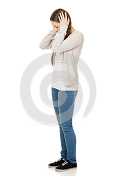 Teen woman covering ears with hands.