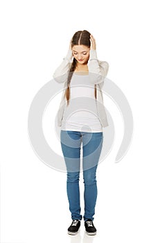 Teen woman covering ears with hands.