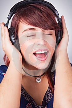 Teen woman listening music at headphones