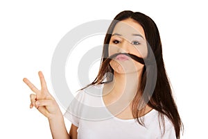 Teen woman putting hair like moustache.