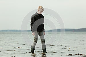 Teen youth stepping in water during high tide