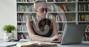 Teenage 17s student girl writing exercise studying using laptop