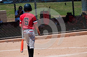 Teenage baseball player from behind.