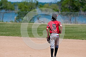Teenage baseball shortstop on field with copy space.