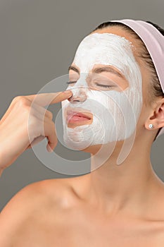 Teenage beauty girl touch nose facial mask