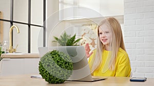 Teenage blond girl, student of school college learn to watch an online webinar webcast of class looking at laptop e