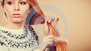 Teenage blonde girl brushing her hair with comb