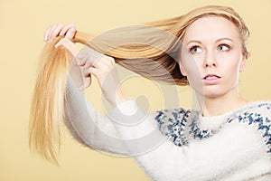 Teenage blonde girl brushing her hair with comb