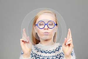 Teenage blonde woman making promise gesture