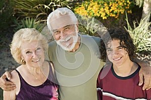 Teenage boy (13-15) with grandparents outdoors elevated view portrait.