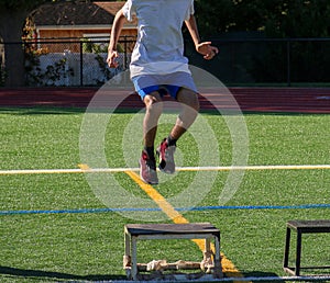 Teenage boy in the air jumping on to a plyo box