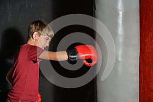 A teenage boy angrily punches a sports bag in the gym photo